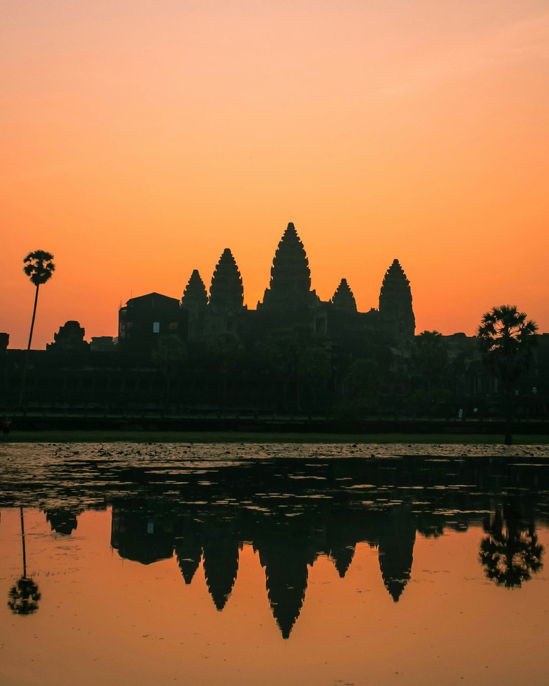 Angkor Wat temple at sunrise with reflection in water