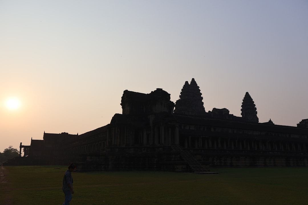 Angkor Wat temple silhouetted against sunset